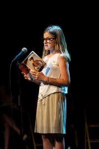 Lily en pleine lecture sur scène